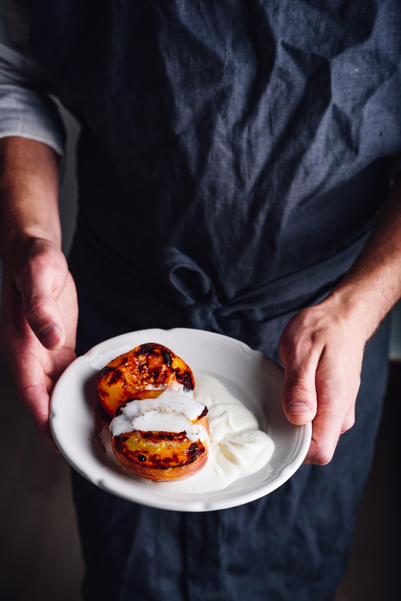 Instructor plating a rustic dish in warm kitchen